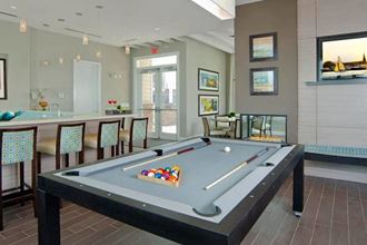 a games room with a pool table and a bar