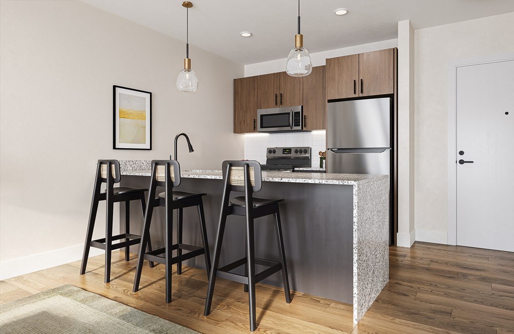 a kitchen with a large island with three bar stools at Boardwalk at Research Park in Alabama 35811