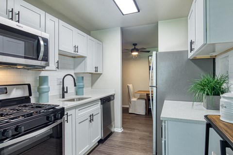 a kitchen with white cabinets and a stove and a microwave