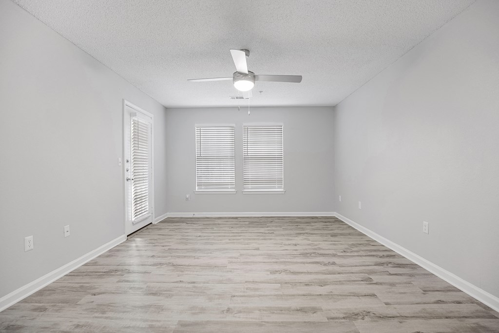 an empty living room with a ceiling fan and a window at Midtown Crossing in NC 27609
