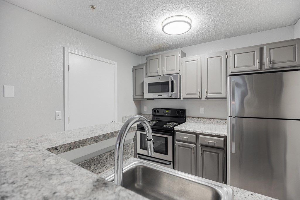 a kitchen with granite counter tops and stainless steel appliances at Midtown Crossing in Raleigh, North Carolina 27609