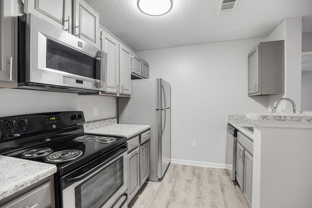 a kitchen with stainless steel appliances and white cabinets at Midtown Crossing in NC 27609