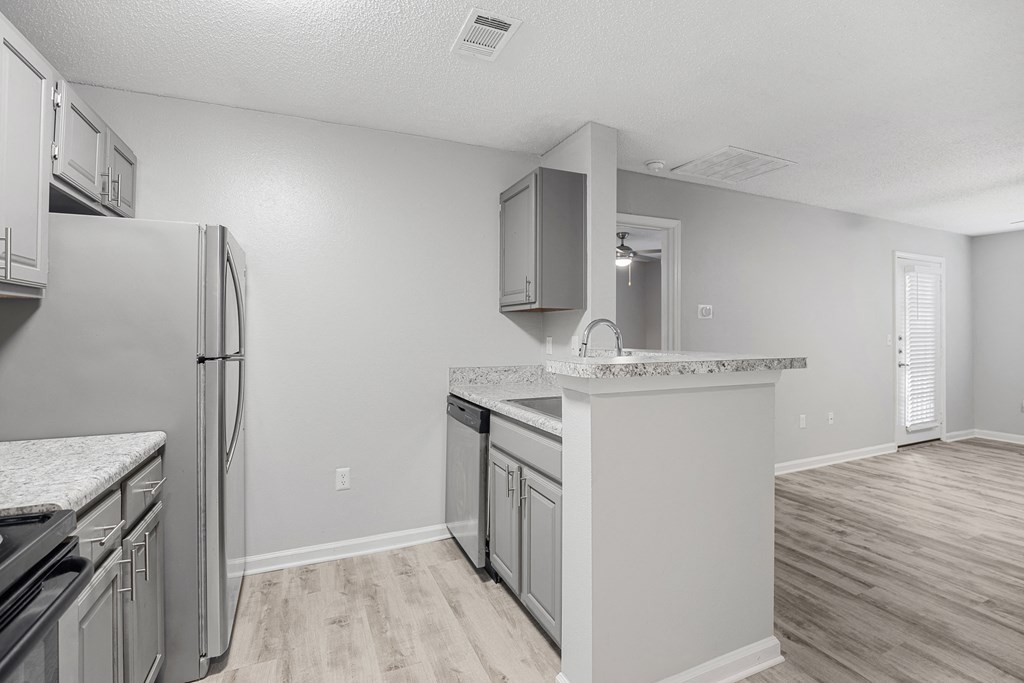 the spacious kitchen with stainless steel appliances and white countertops at Midtown Crossing in Raleigh, North Carolina