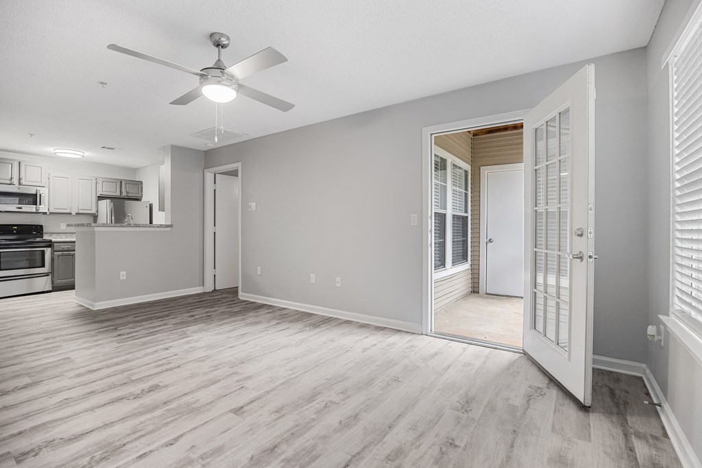 an empty living room and kitchen with a ceiling fan at Midtown Crossing in Raleigh, NC 27609