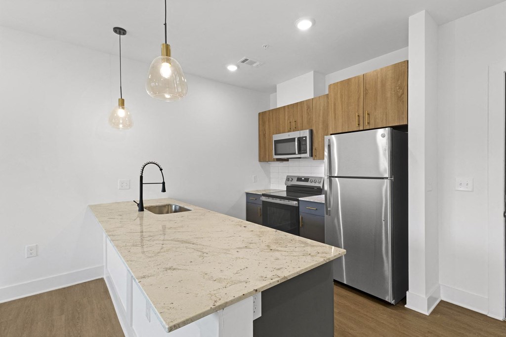 A kitchen with a granite countertop and stainless steel appliances.at Boardwalk at Research Park, Huntsville, AL 35806