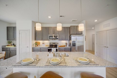 A modern kitchen with a dining table set for two.