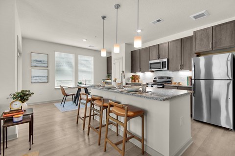 spacious kitchen with stainless steel appliances and a large island with stools spacious kitchen with stainless steel appliances and a large island with stools at The Enclave at Deer Moss Creek, Niceville