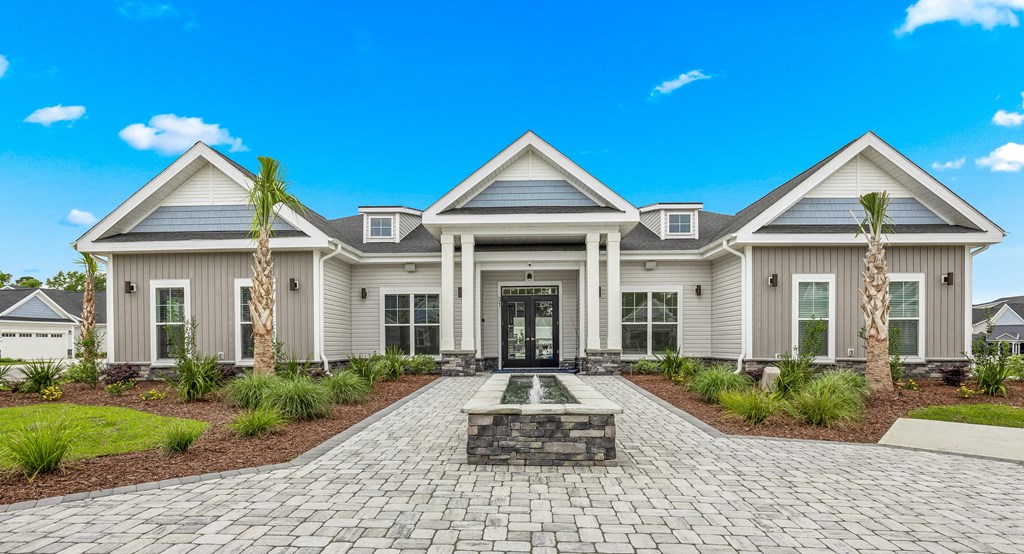 a large house with a fountain in front of it