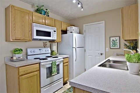 A kitchen with wooden cabinets and a white refrigerator.