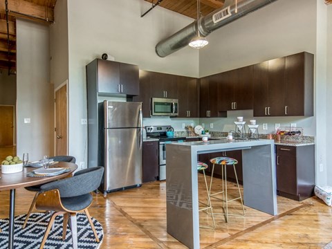 a kitchen with stainless steel appliances and a table with chairs