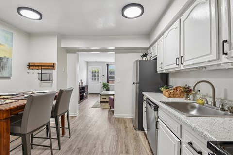 A kitchen with a dining table and chairs.