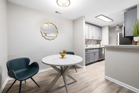 A modern kitchen with a round table and a single chair.