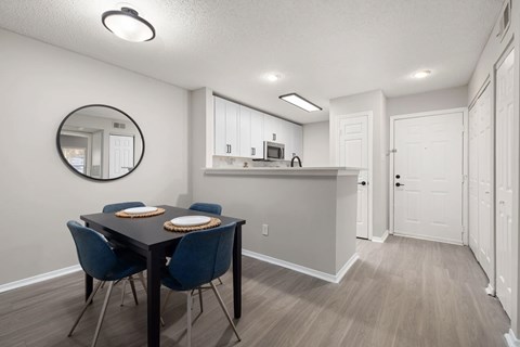 A dining room with a table and chairs.
