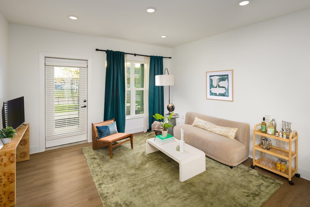 A living room with a couch, a chair, a coffee table, and a TV.