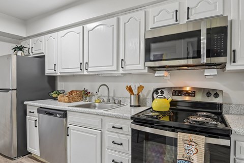A kitchen with white cabinets and a black stove top.
