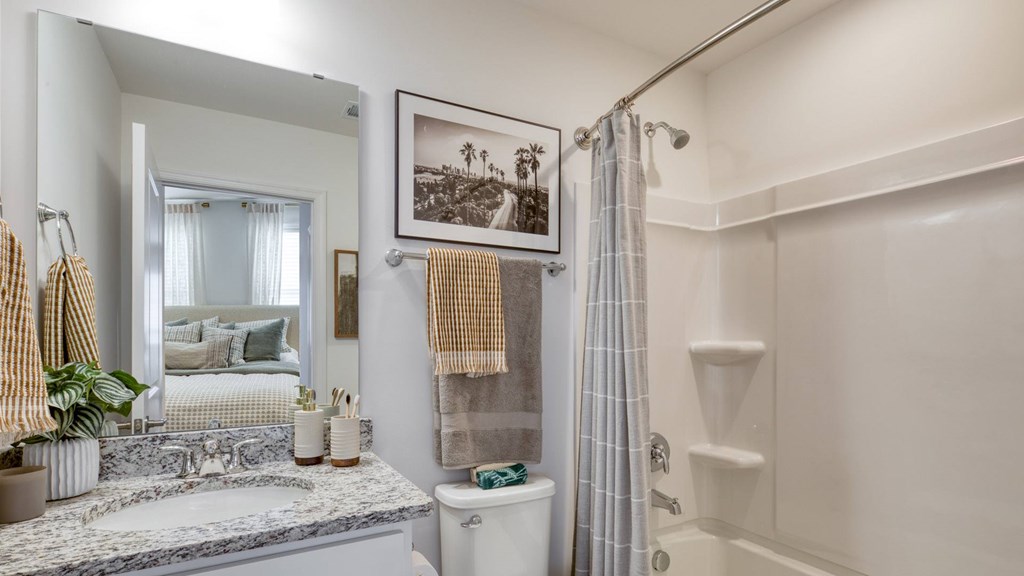 A bathroom with a marble countertop and a shower with a glass door at The Mark Townhomes Apartments, Harrisonburg, VA, 22801