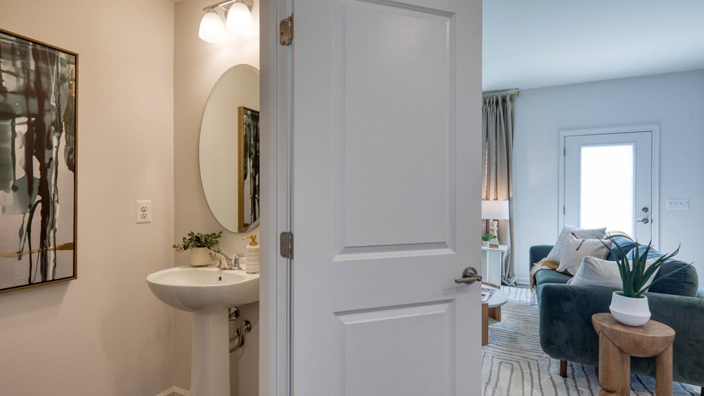 A bathroom with a white sink and a mirror on the wall at The Mark Townhomes Apartments, Virginia, 22801