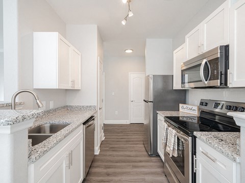 a kitchen with granite counter tops and white cabinets
