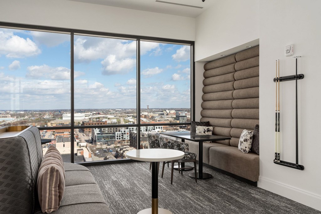 A modern living room with a view of the cityscape outside the large window.