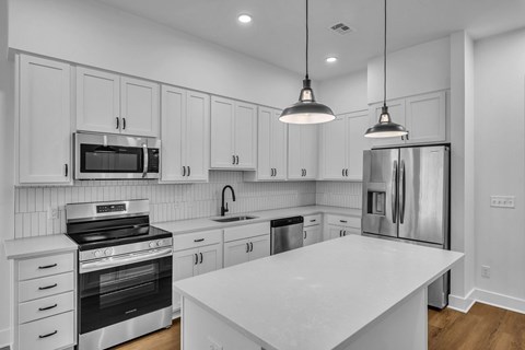 A modern kitchen with white cabinets and stainless steel appliances.