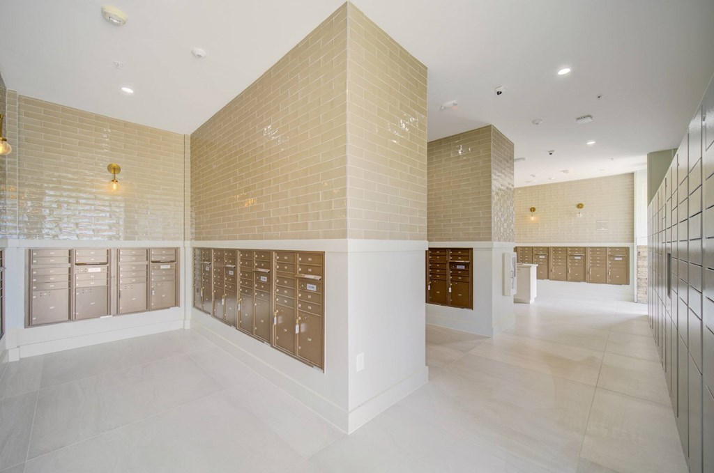 A hallway with a white floor and beige tiled walls.