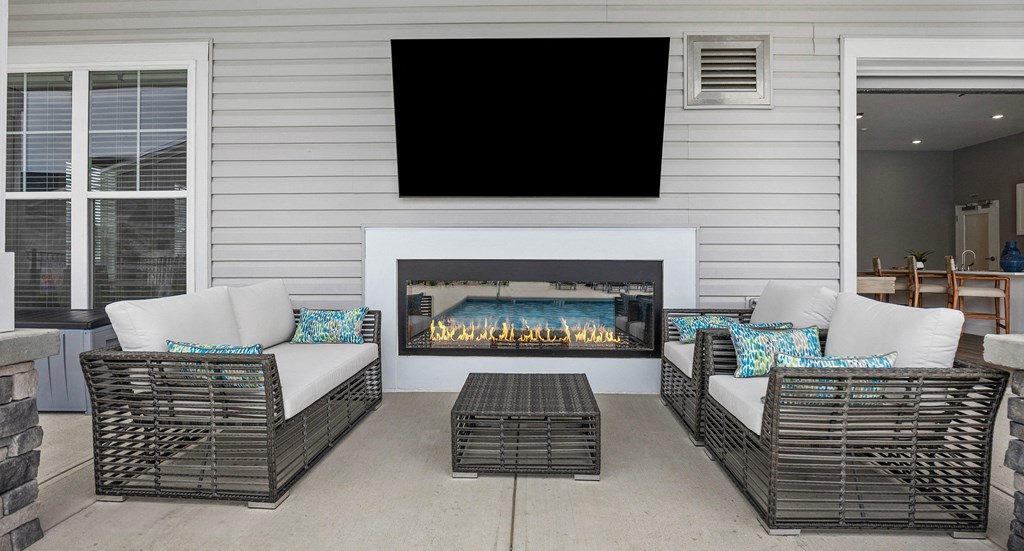 the screened porch has a gas fireplace with a tv above it