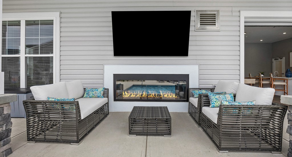 the screened porch has a gas fireplace with a tv above it