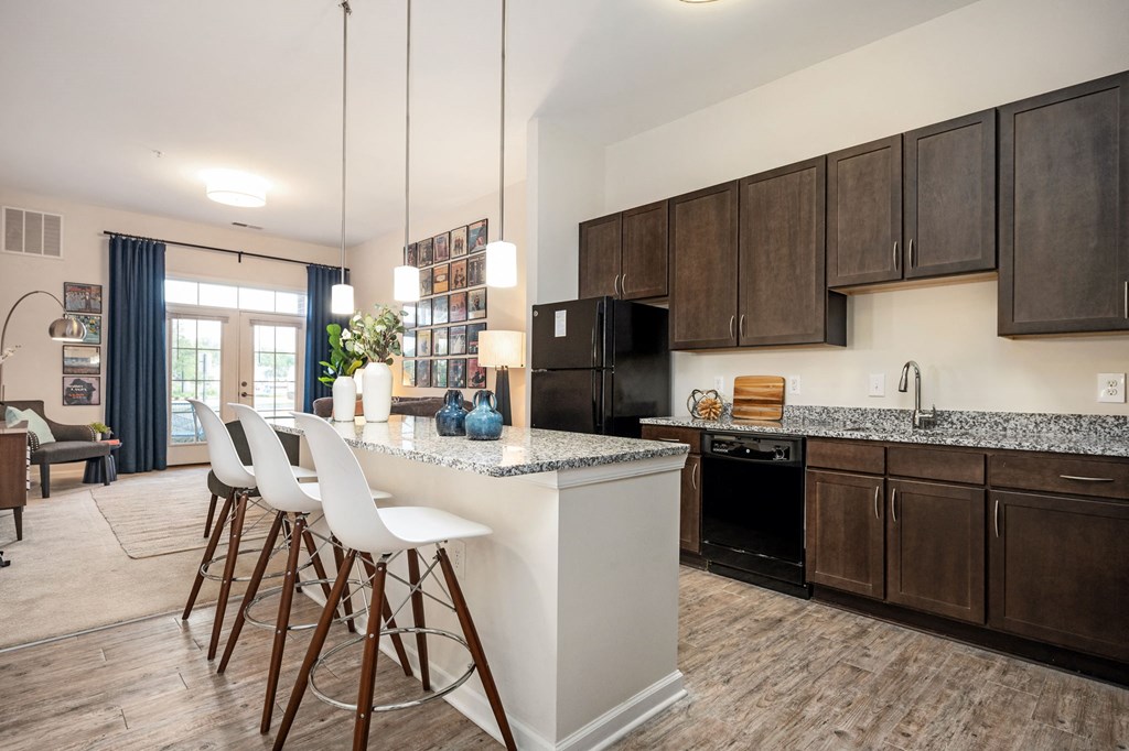 A kitchen with a white island and brown bar stools.