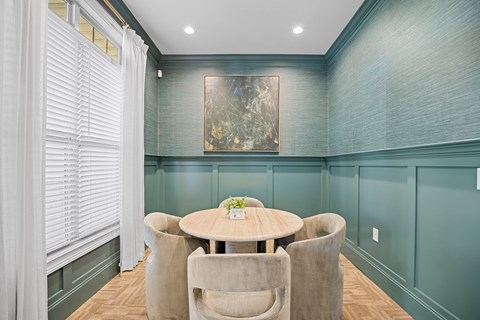 A dining room with a round table and chairs.