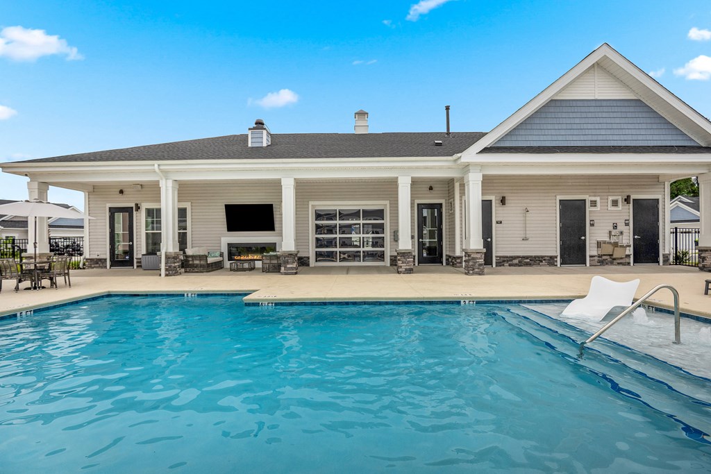 a swimming pool with a house in the background