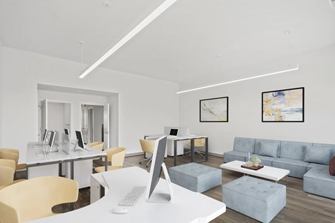 a living room with couches and a desk with a computer