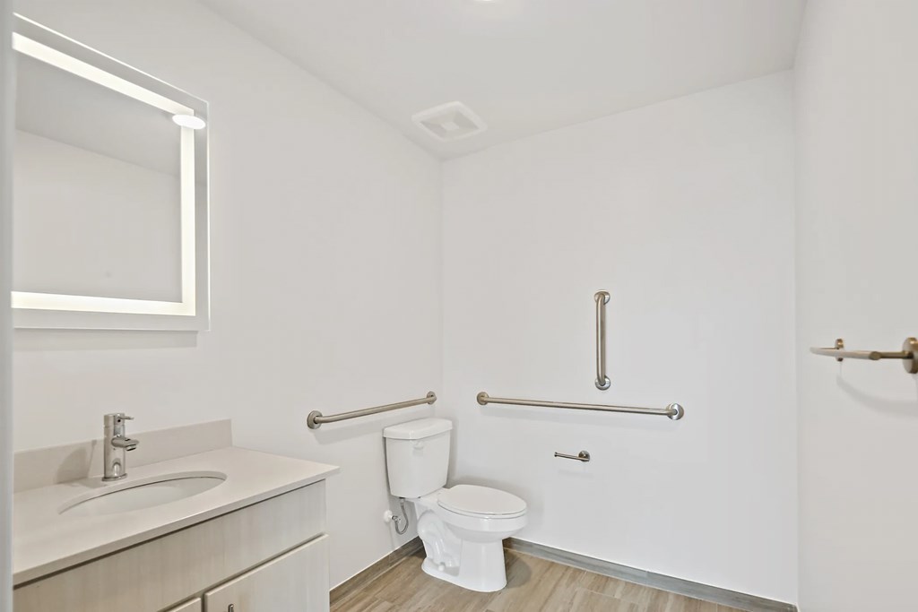 a bathroom with a toilet and a sink and a mirrorat Metropolis Apartments, Glen Allen, VA 23060