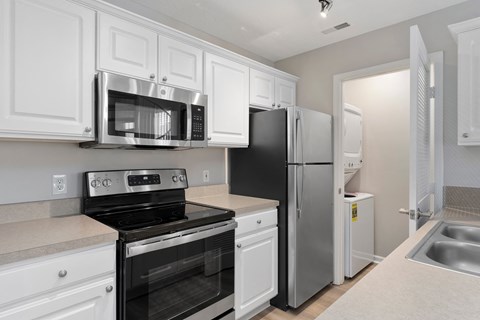 A kitchen with white cabinets and black appliances.