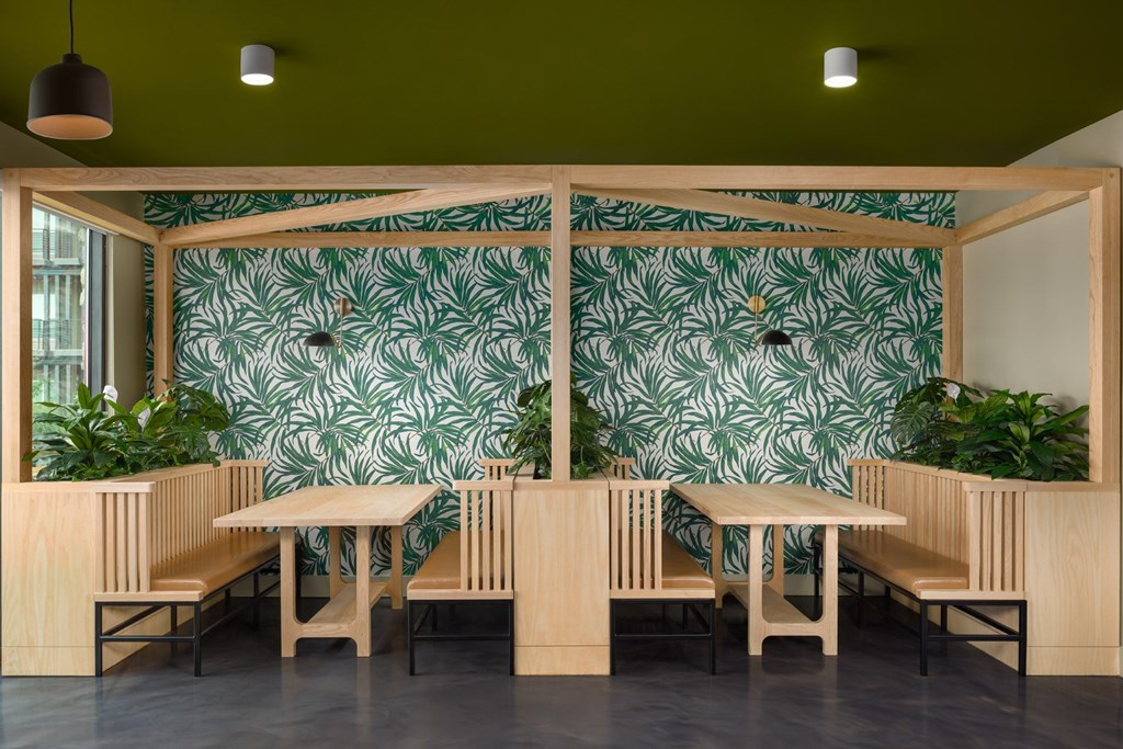 A room with a green wallpaper and wooden furniture.