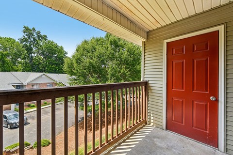 A red door is on the side of a house.