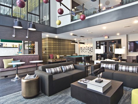 A modern living room with a pool table and a bar area.