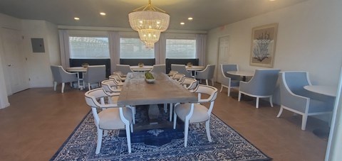 A dining room with a large table and chairs.