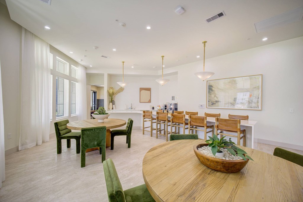 A dining room with a wooden table and green chairs.