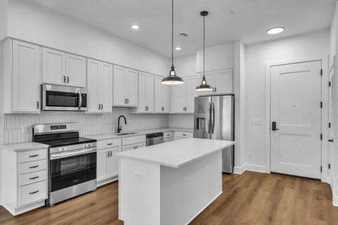 A modern kitchen with white cabinets and a central island.