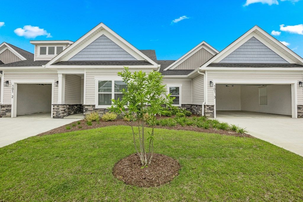 a house with a yard and a tree in front of it