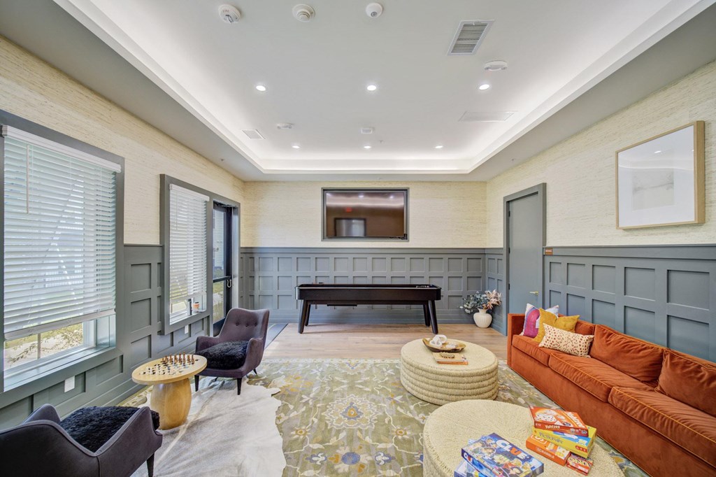 A living room with a brown couch, a coffee table, and a piano.