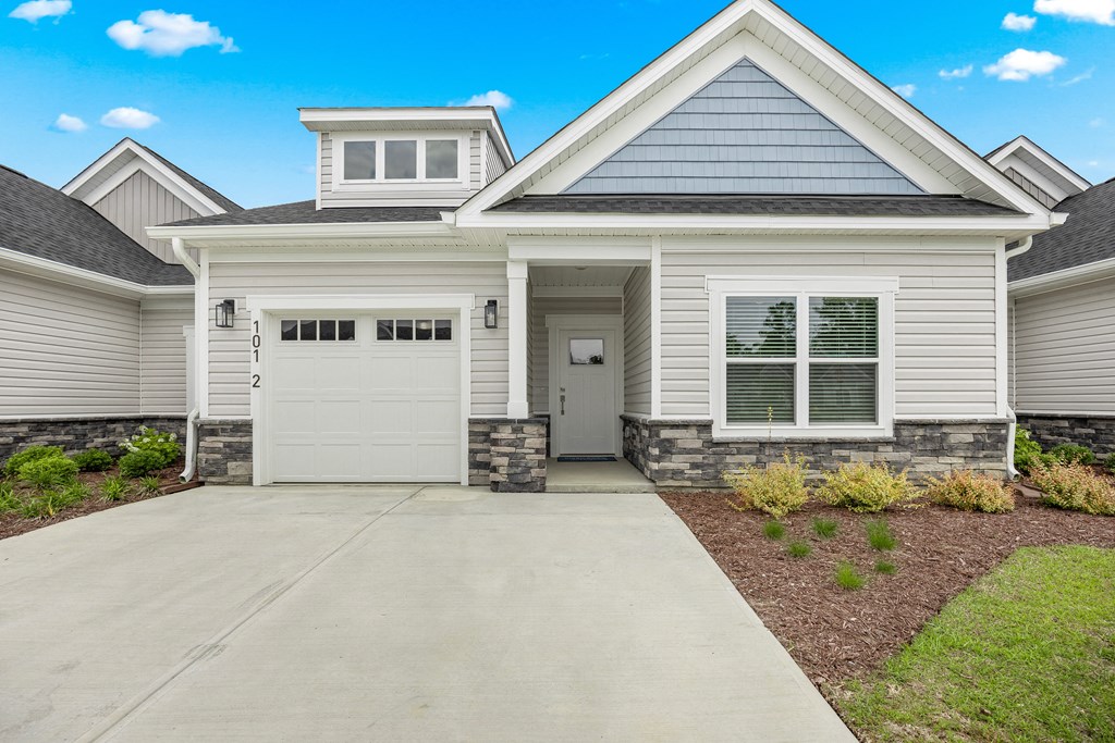 a white house with a white garage door and a driveway