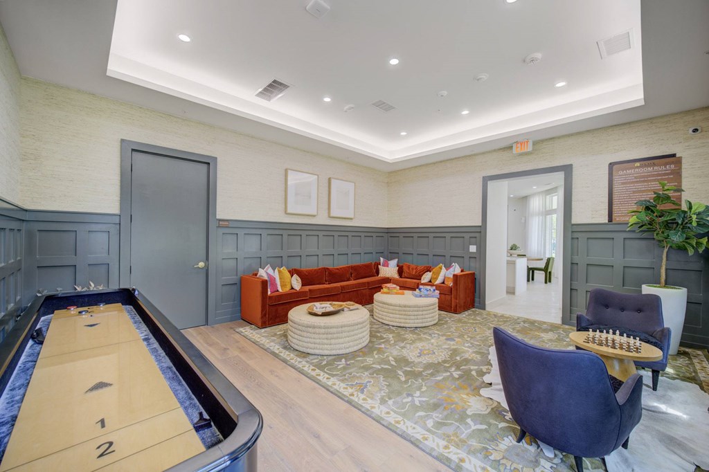 A billiard table is in the middle of a room with a couch and chairs.