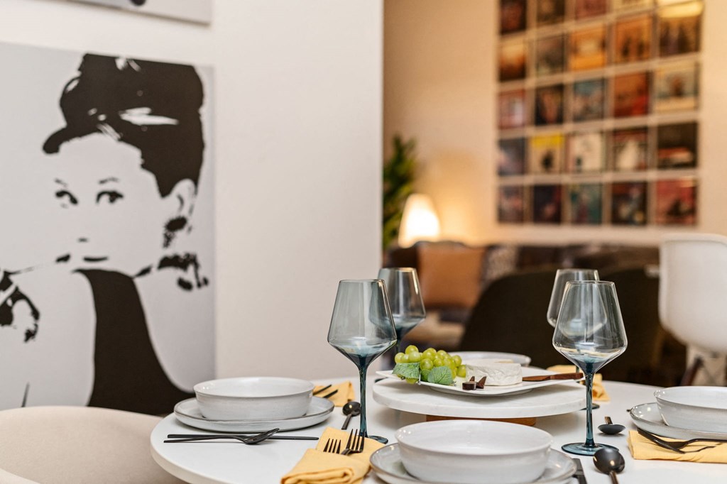 A dining table set with plates, glasses and a yellow napkin.