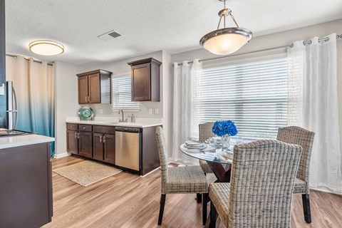 A modern kitchen with a dining table set for two.