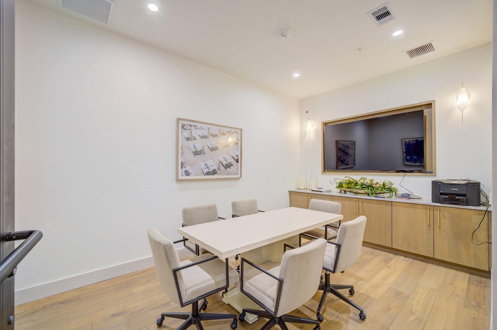 A conference room with a white table and chairs.