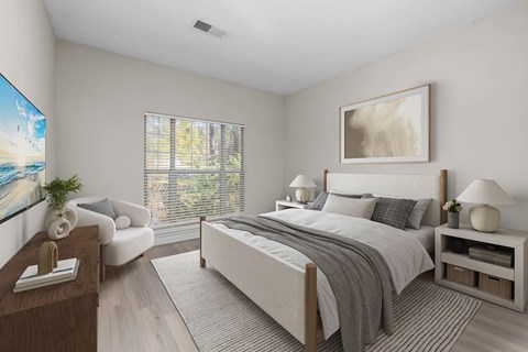 A well-lit bedroom with a large bed, a couch, and a painting on the wall.