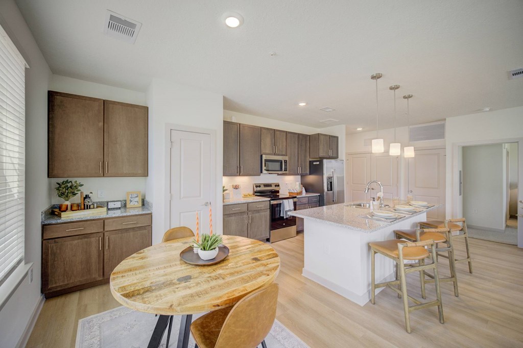 A modern kitchen with wooden furniture and a white island.