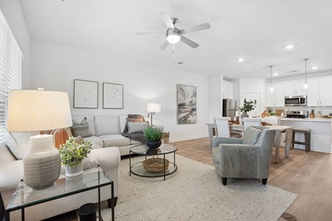 a living room with couches and chairs and a ceiling fan