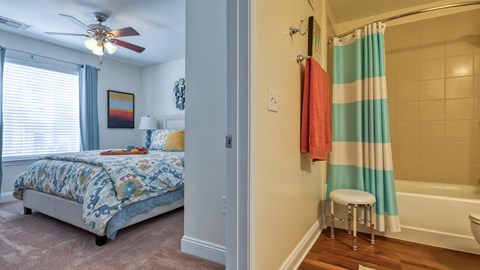 A bedroom with a bed and a bathroom with a shower.